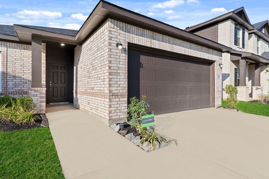 The front entry is warm and inviting, featuring a low-maintenance landscape design and a welcoming walkway that enhances the home’s attractive facade.