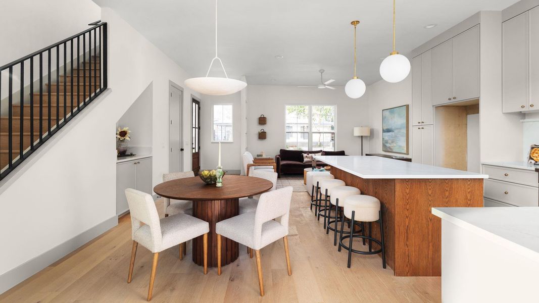 Dining room featuring stairway, light wood-style flooring, and a ceiling fan