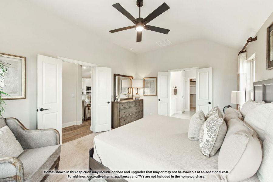 Spacious master bedroom with ceiling fan, carpet flooring, and doors leading to ensuite bathroom and walk-in closet