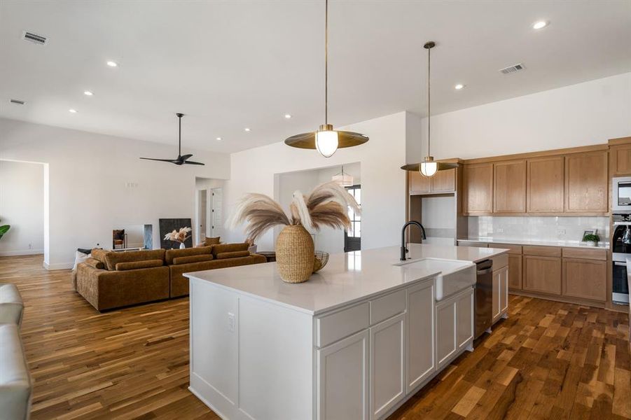 Kitchen featuring appliances with stainless steel finishes, a kitchen island with sink, sink, and dark hardwood / wood-style floors