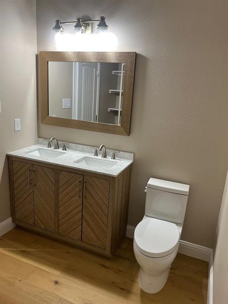 Bathroom featuring toilet, vanity, and hardwood / wood-style floors