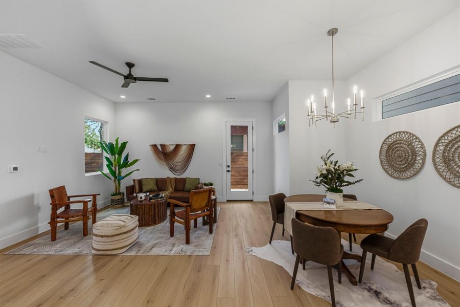 Dining space featuring light wood-style floors, a ceiling fan, and suspended lighting