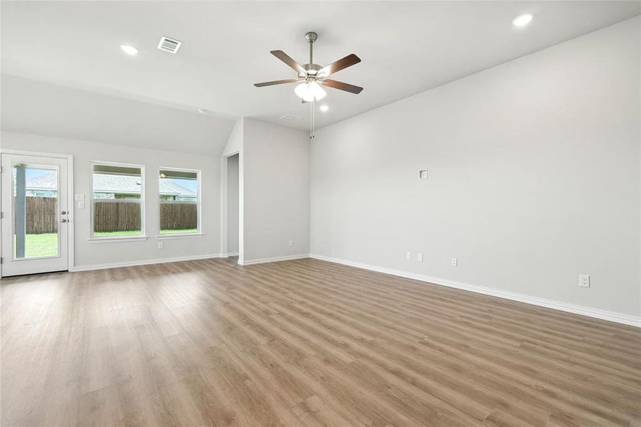 Empty room with ceiling fan, light wood-type flooring, recessed lighting, and vaulted ceiling