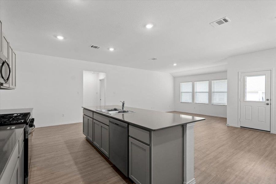 An open-concept living space features an inviting kitchen island and abundant natural light from multiple windows. An open-concept living space features an inviting kitchen island and abundant natural light from multiple windows.