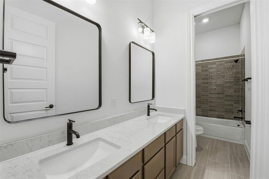 Dual vanity featuring matte black framed mirrors, white quartz countertops, and dark wood-finish cabinetry