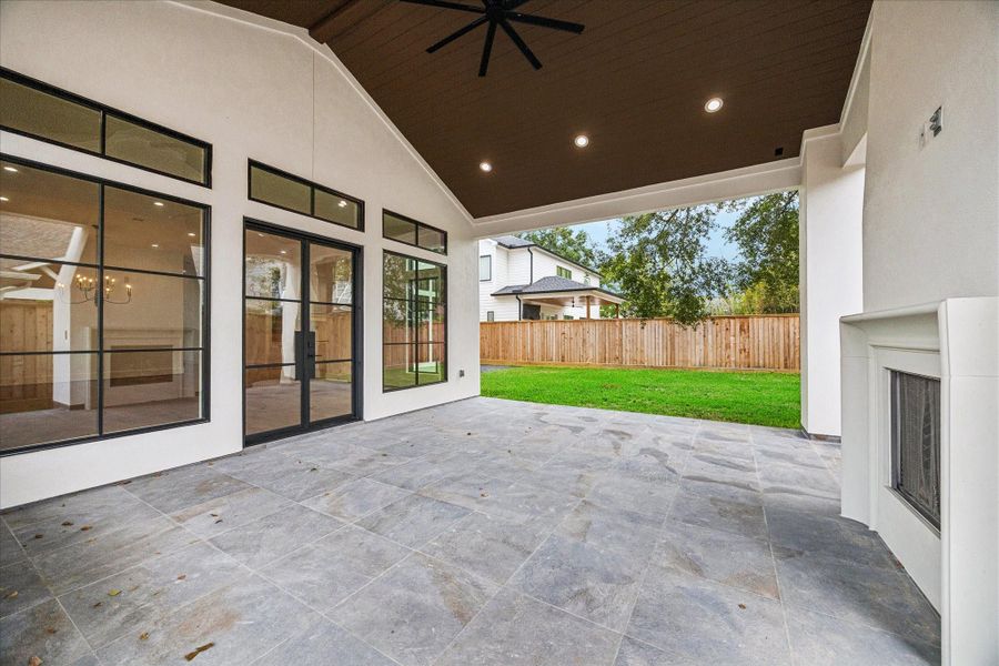 Soaring ceilings, extended roofline, and oversized tile flooring shape an outdoor living environment connected through iron and glass doors. Clerestory windows continue the home’s architectural rhythm, supported by the same high performance insulation envelope. Soaring ceilings, extended roofline, and oversized tile flooring shape an outdoor living environment connected through iron and glass doors. Clerestory windows continue the home’s architectural rhythm, supported by the same high performance insulation envelope.