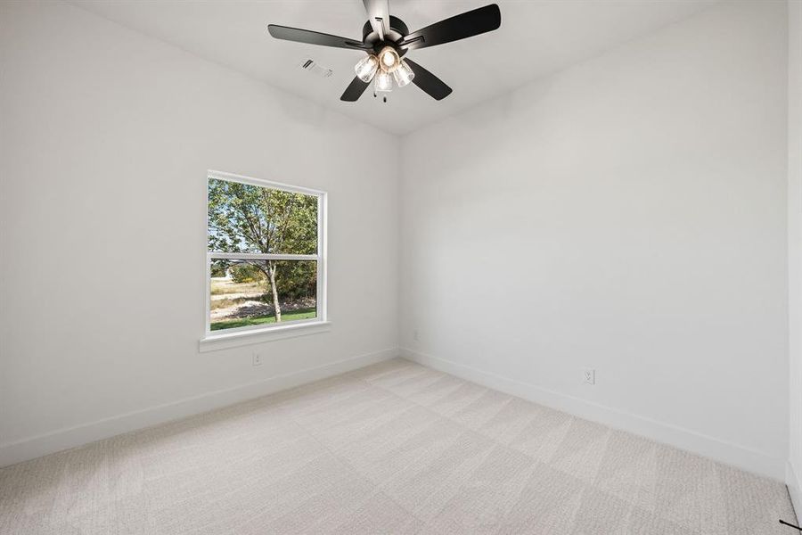 Spare room featuring light colored carpet and a ceiling fan Spare room featuring light colored carpet and a ceiling fan