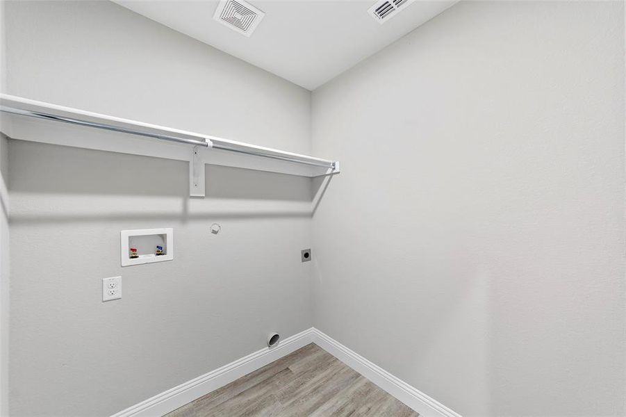 Laundry room with hookup for an electric dryer, washer hookup, hardwood / wood-style flooring, and gas dryer hookup