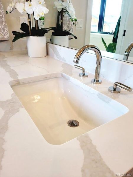 spacious vanities with quartz tops, polished nickel hardware