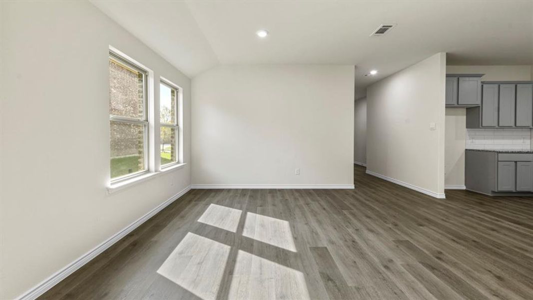 Spacious room featuring wood-finish flooring, recessed lighting, and multiple windows