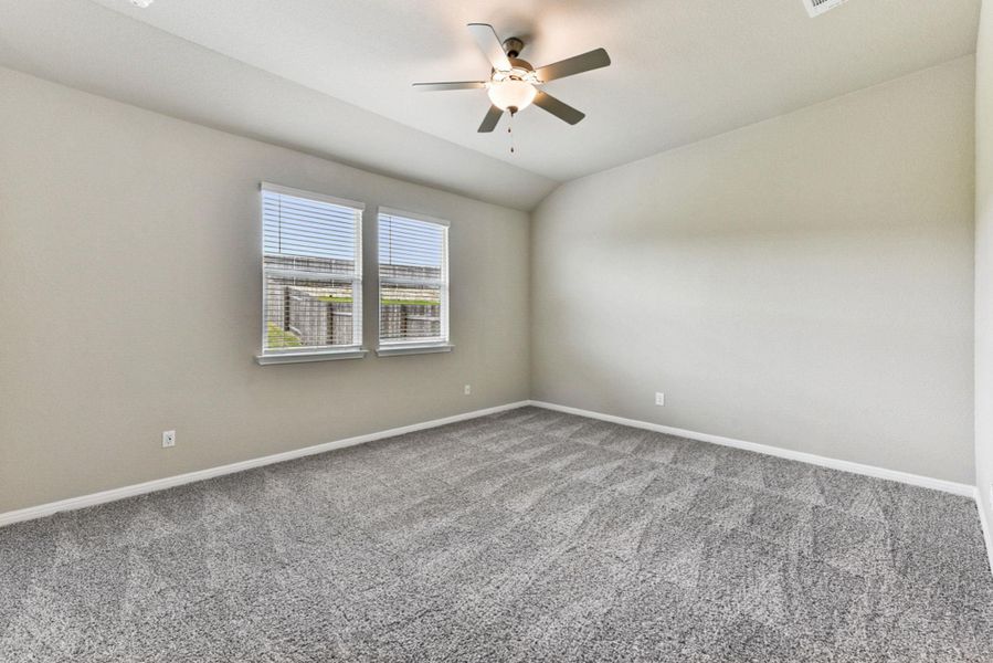 Primary bedroom on main floor with ceiling fan, new carpet & great view of backyard