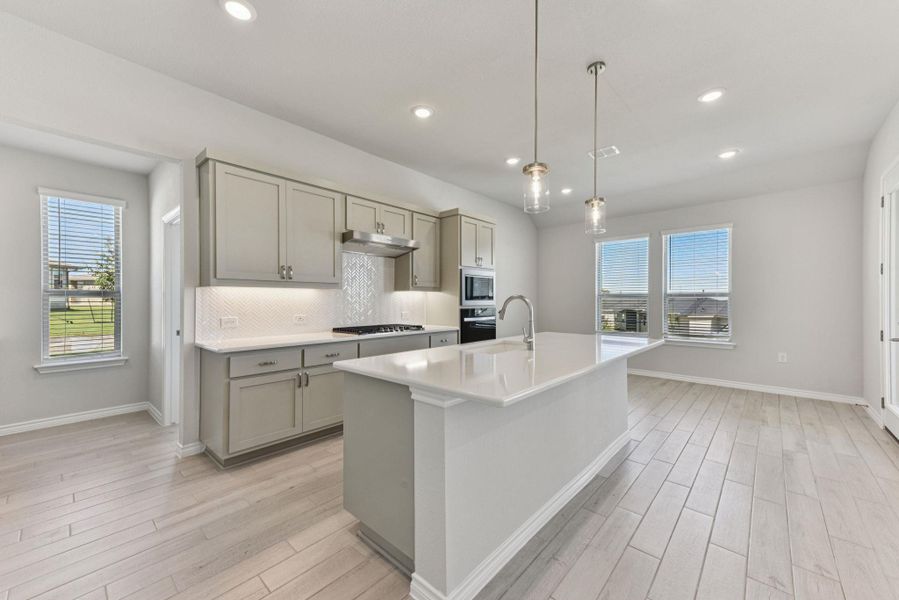 Kitchen featuring gray cabinetry, hanging light fixtures, healthy amount of natural light, backsplash, and recessed lighting Kitchen featuring gray cabinetry, hanging light fixtures, healthy amount of natural light, backsplash, and recessed lighting