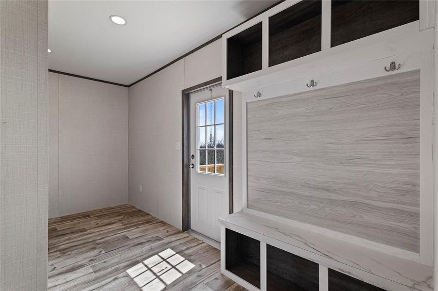 Mudroom featuring light wood-style floors, ornamental molding, and recessed lighting