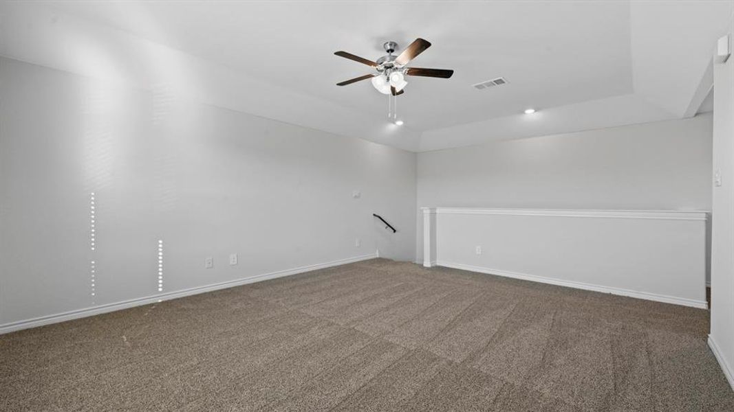 Carpeted empty room with ceiling fan and baseboards Carpeted empty room with ceiling fan and baseboards