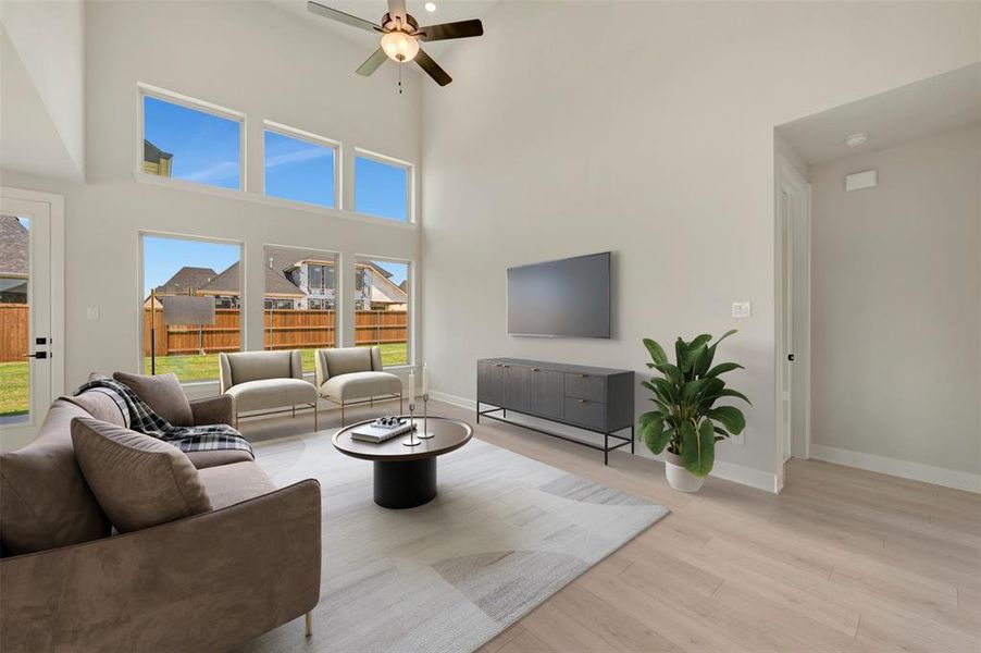 Living area featuring a soaring vaulted ceiling, wood-finish flooring, and a ceiling fan