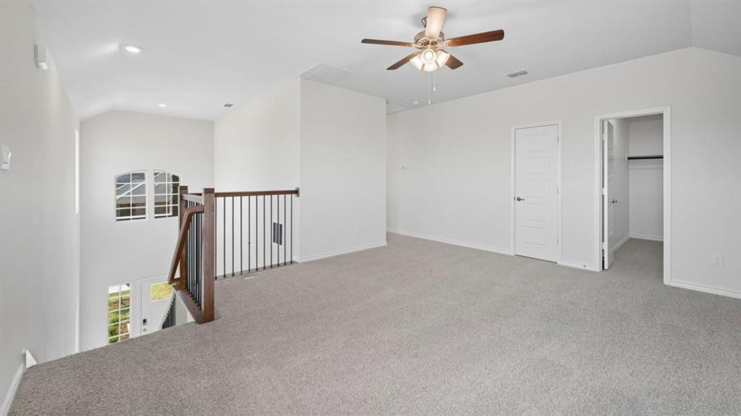 Unfurnished room featuring carpet floors, ceiling fan, and vaulted ceiling Unfurnished room featuring carpet floors, ceiling fan, and vaulted ceiling