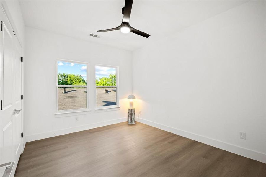 Spare room with wood finished floors and ceiling fan