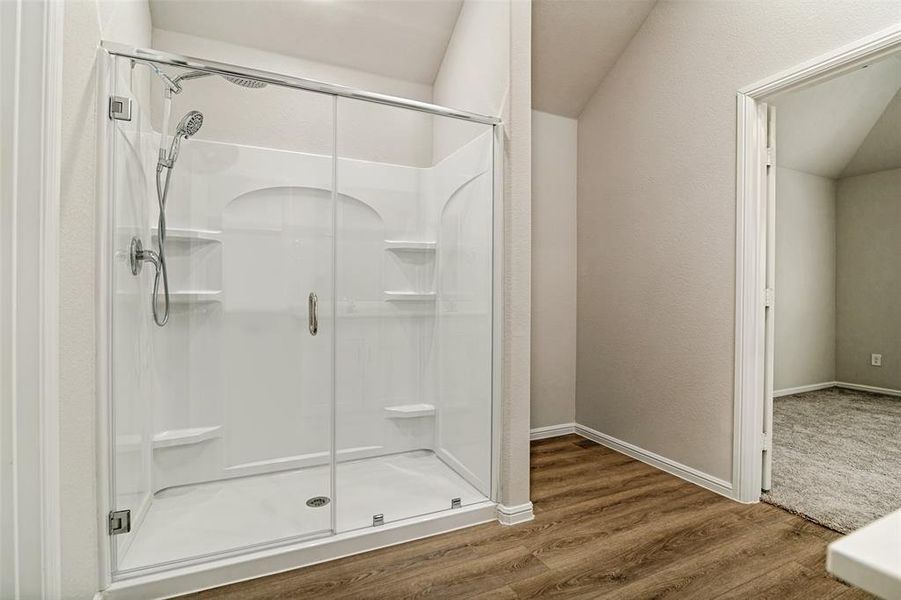 Walk-in shower with a glass enclosure, multiple built-in shelving niches, and a handheld showerhead Walk-in shower with a glass enclosure, multiple built-in shelving niches, and a handheld showerhead