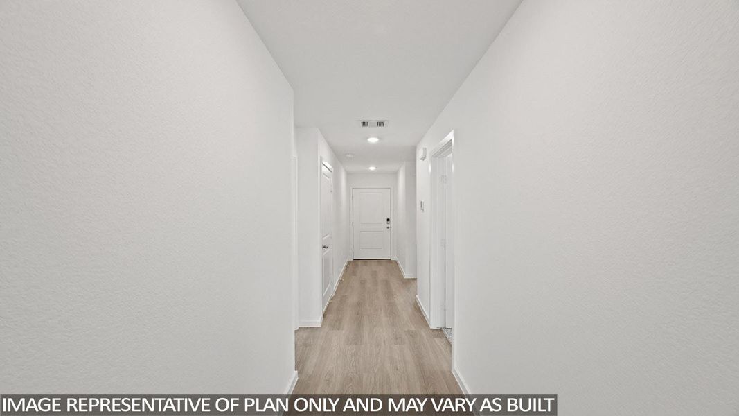 Hallway featuring light wood-style flooring, a textured wall, and recessed lighting