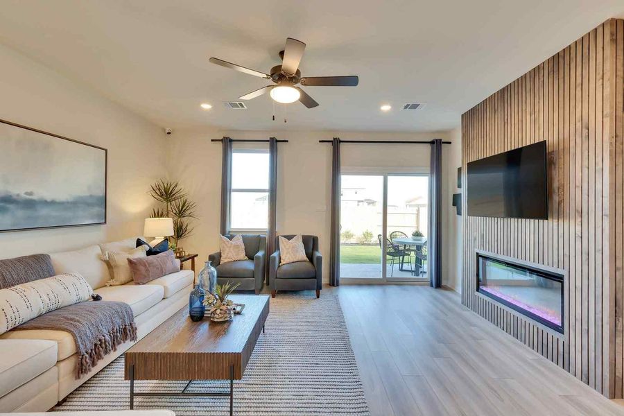 Natural light floods this inviting living area, showcasing a contemporary fireplace and easy access to outdoor space.