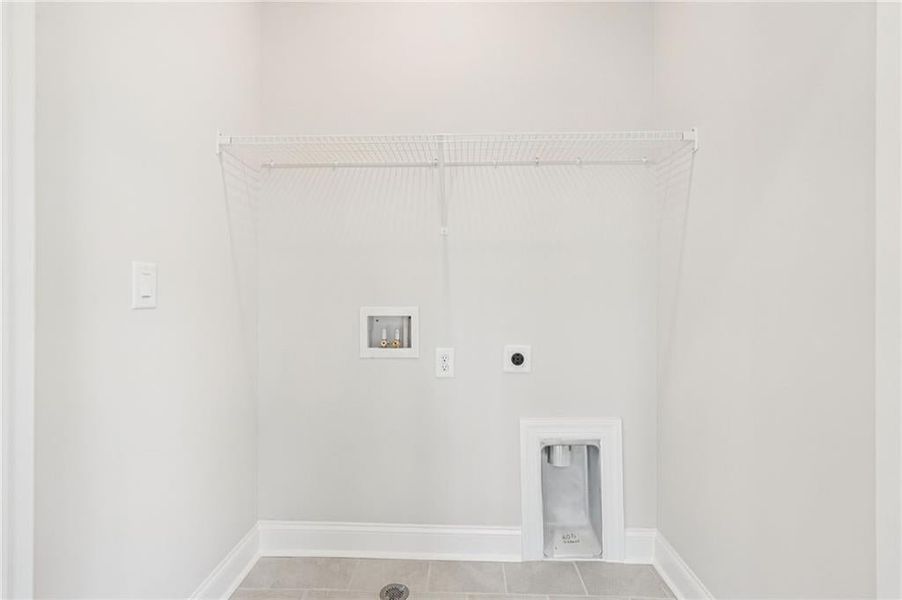 Laundry room featuring hookup for a washing machine, electric dryer hookup, and tile patterned flooring