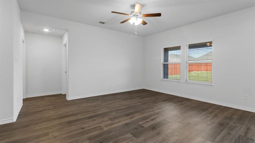Spare room featuring dark wood-type flooring and ceiling fan