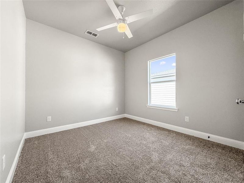 Carpeted room featuring a ceiling fan, a window with white trim, light gray walls, and white baseboards Carpeted room featuring a ceiling fan, a window with white trim, light gray walls, and white baseboards
