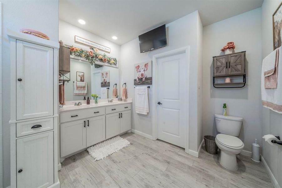 Bathroom featuring hardwood / wood-style floors, vanity, and toilet