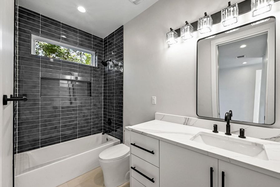 3rd Floor Bathroom with stylish tile and finishes. (This is Unit #2 - each Unit has the same layout, however a few differing details such as light fixtures, custom cabinet/backsplash/tile colors)