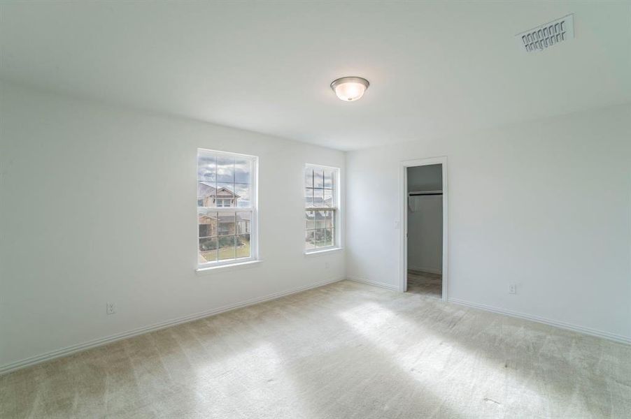 Unfurnished bedroom featuring a walk in closet and carpet Unfurnished bedroom featuring a walk in closet and carpet