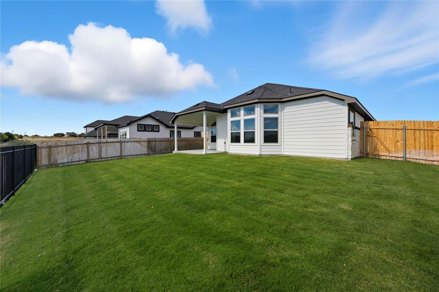 Back of property featuring a patio and a fenced backyard