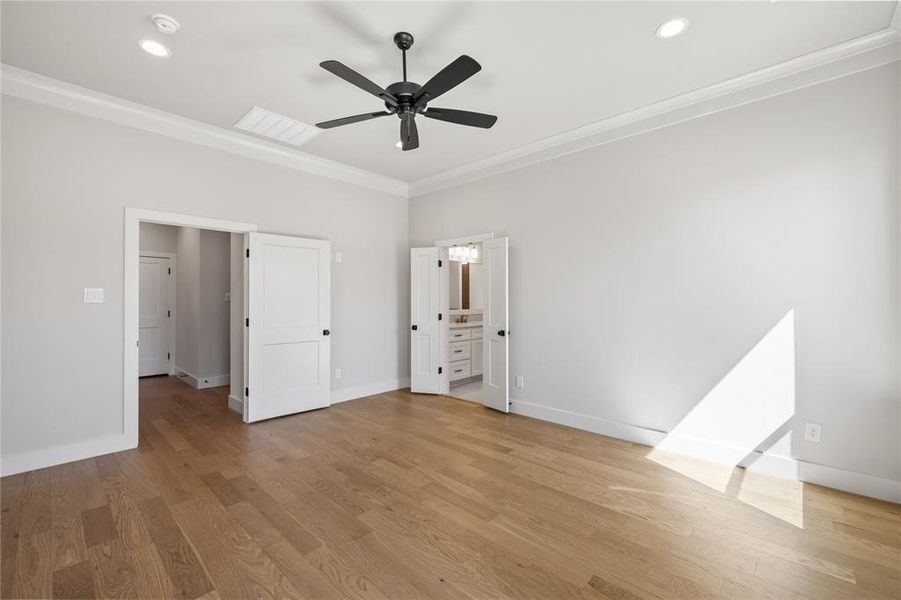 Unfurnished bedroom with crown molding, light wood-style floors, a ceiling fan, connected bathroom, and recessed lighting