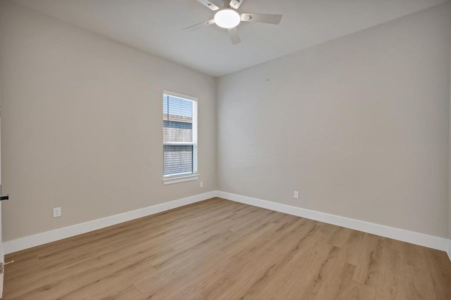 Unfurnished room featuring baseboards, light wood-style floors, and a ceiling fan Unfurnished room featuring baseboards, light wood-style floors, and a ceiling fan