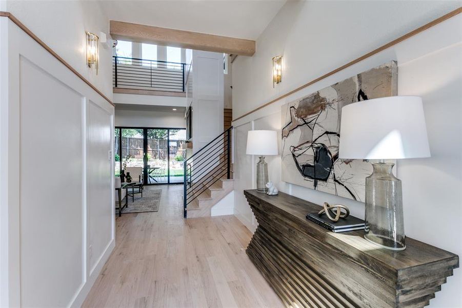 Entrance foyer with a high ceiling and light hardwood / wood-style flooring