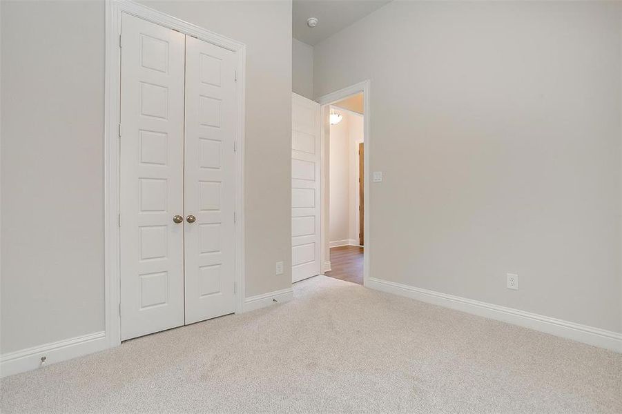 Unfurnished bedroom featuring a closet and light carpet