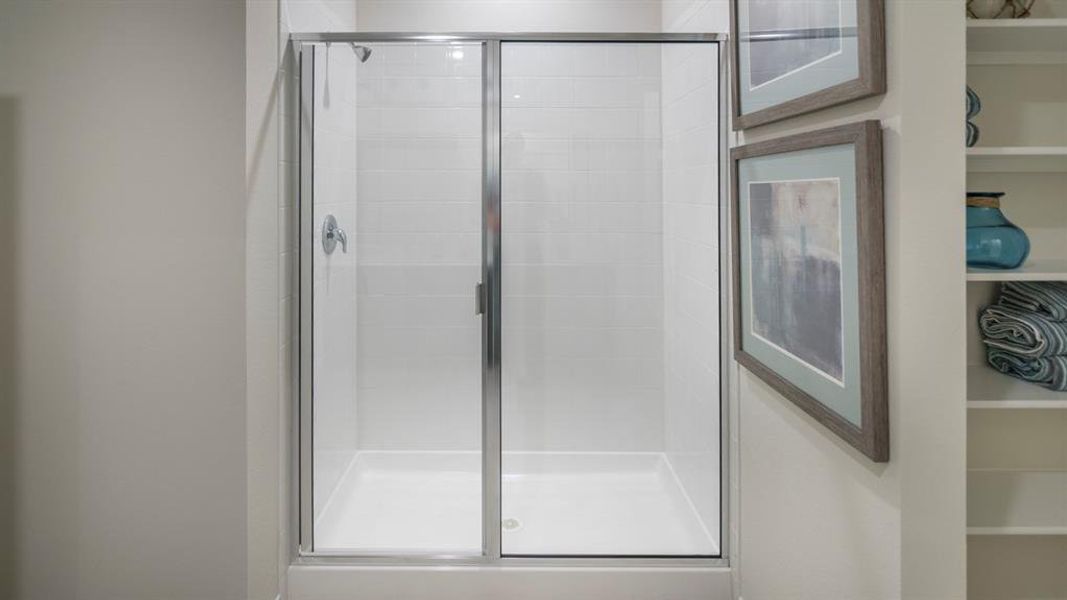 Bathroom featuring a shower stall and a closet
