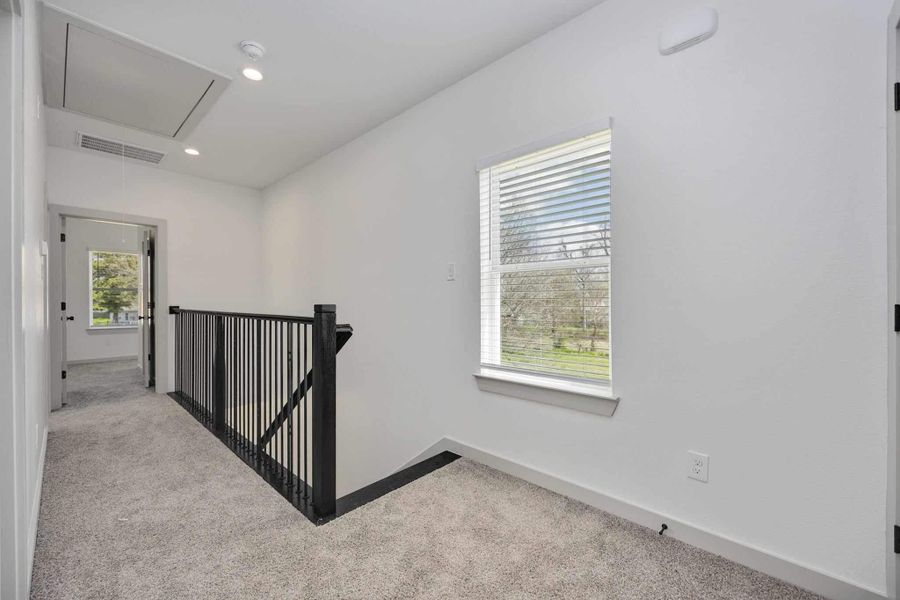Second-floor landing with natural light and views overlooking the staircase below. Ideal as a small reading nook or transition space between bedrooms.