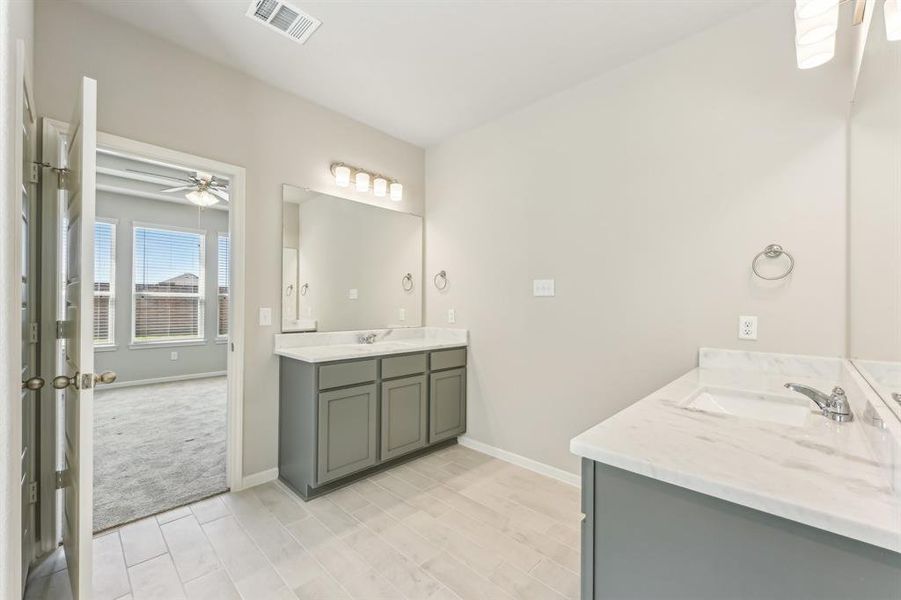 The double vanity offers ample counter space, perfect for getting ready in the morning. The sleek cabinetry and neutral tones create a clean and contemporary look.