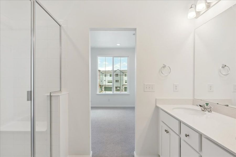 A bathroom with a sink and a shower unit.