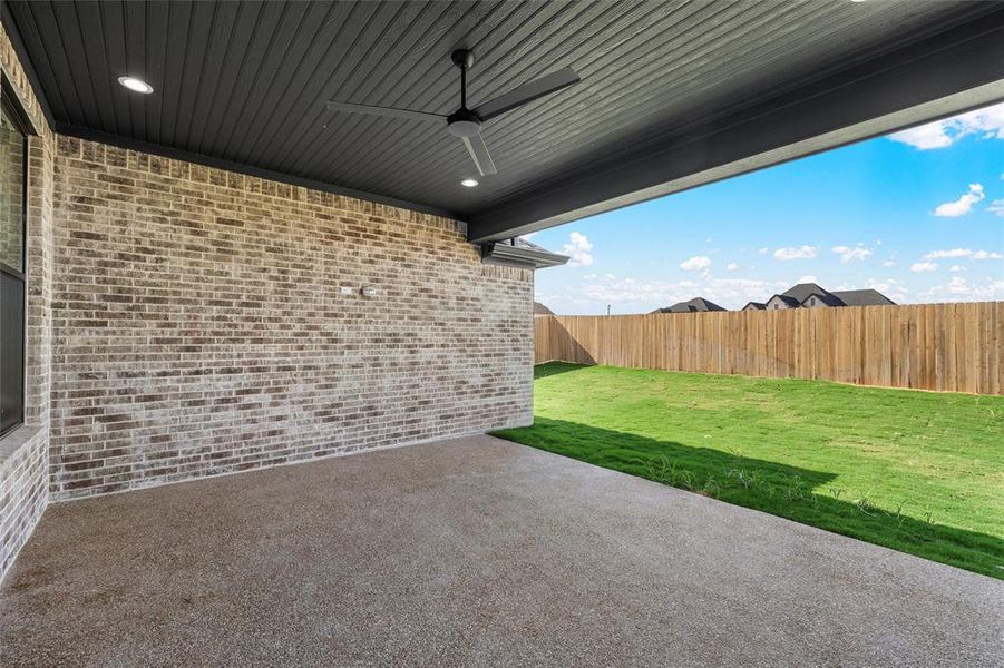 Fenced backyard featuring a ceiling fan and a patio area Fenced backyard featuring a ceiling fan and a patio area