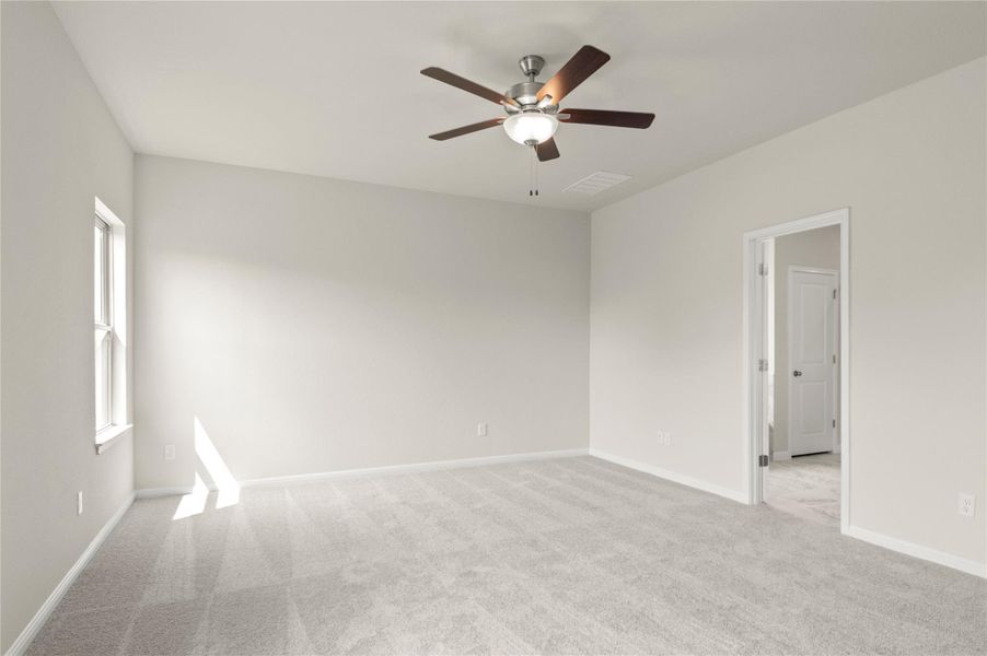 Unfurnished room featuring ceiling fan and light carpet