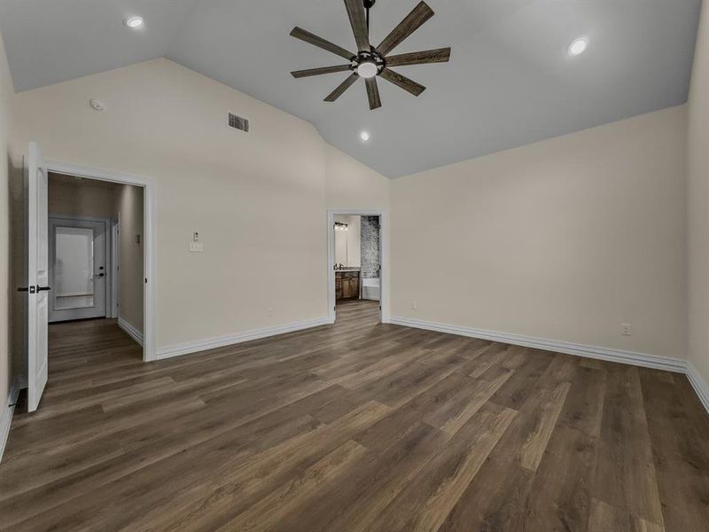Empty room featuring a ceiling fan, recessed lighting, dark wood finished floors, and high vaulted ceiling Empty room featuring a ceiling fan, recessed lighting, dark wood finished floors, and high vaulted ceiling