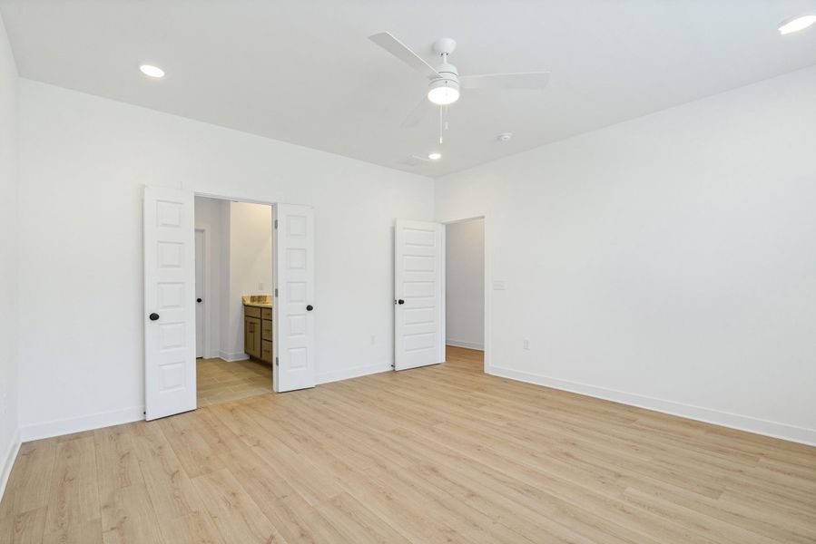 Spacious room with light wood-finish flooring, crisp white walls, and recessed lighting Spacious room with light wood-finish flooring, crisp white walls, and recessed lighting