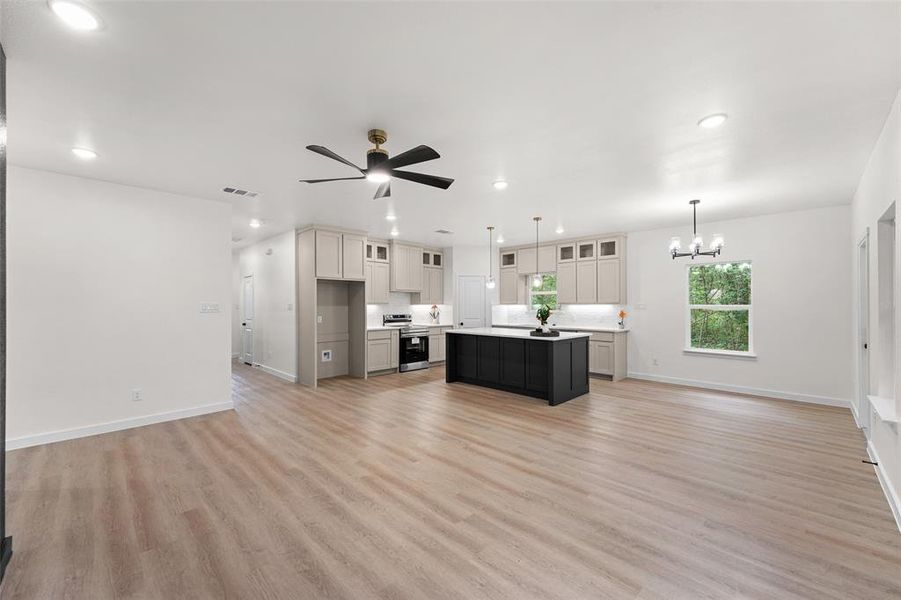 Open-concept living space featuring wood-finish flooring, recessed lighting, and a modern ceiling fan Open-concept living space featuring wood-finish flooring, recessed lighting, and a modern ceiling fan
