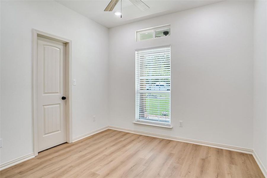 Spare room featuring ceiling fan, a healthy amount of sunlight, and light hardwood / wood-style floors