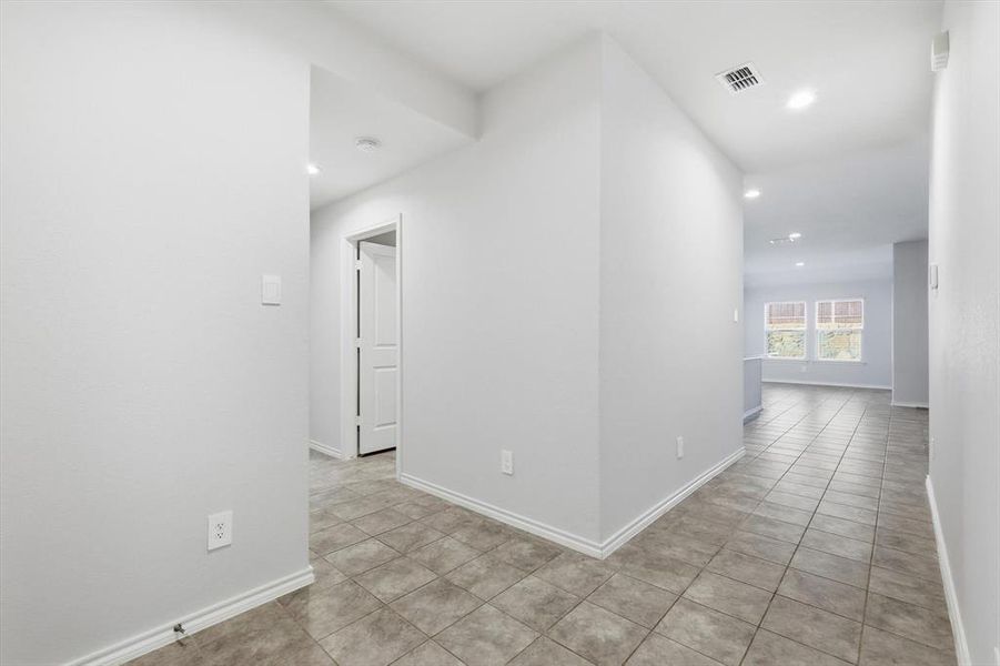 Hallway with light tile patterned floors and recessed lighting-looking towards living and kitchen Hallway with light tile patterned floors and recessed lighting-looking towards living and kitchen