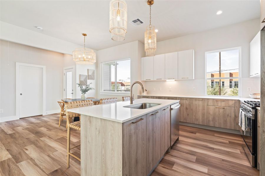 The kitchen is thoughtfully positioned to overlook the dining area, with direct access to the outdoor balcony that extends everyday living beyond the interior.