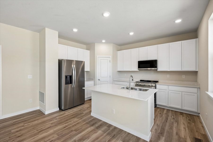 A kitchen with white cabinets.
