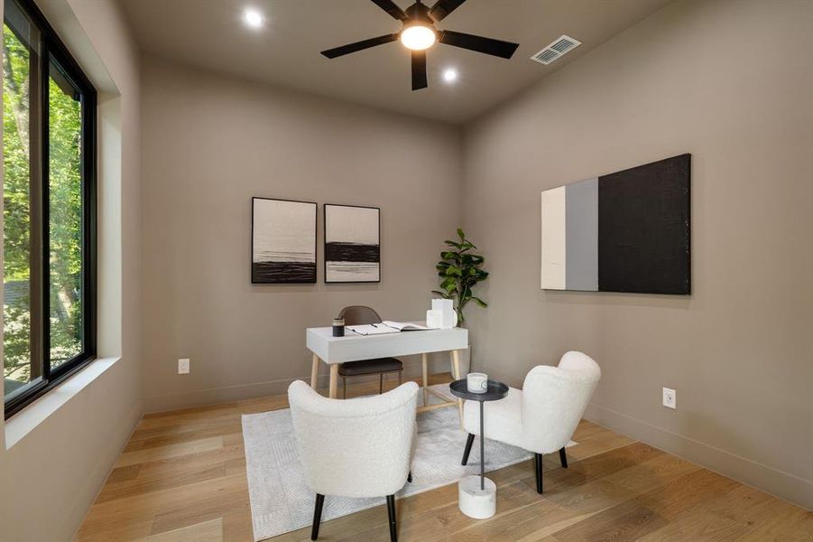 Spacious room featuring light wood-finish flooring, a contemporary ceiling fan with integrated lighting, recessed lighting, and a large window providing ample natural illumination