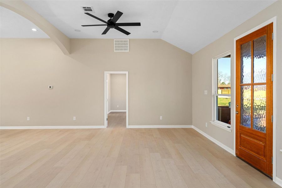 Front entry spotlight: warmwood door, abundant naturallight, and a versatile, openliving space. Vaulted ceilingsand minimalist walls offerendless décor possibilities.
